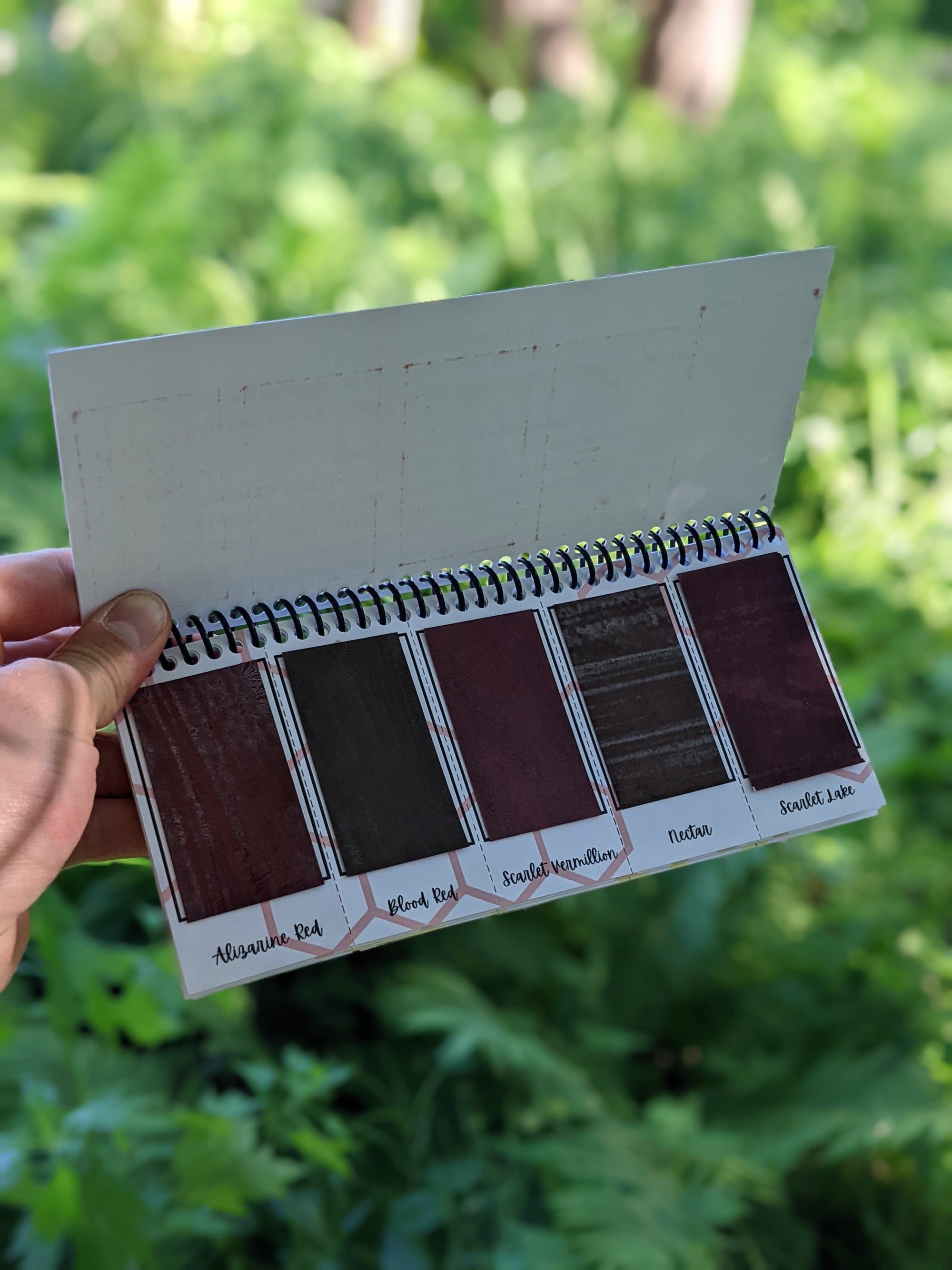 inside sheet of the peerless watercolors portable watercolor palette the Sidekick. This watercolor palette is super vibrant, portable, and easy to use.  this picture is showing of the red paints included in the travel watercolor palette.