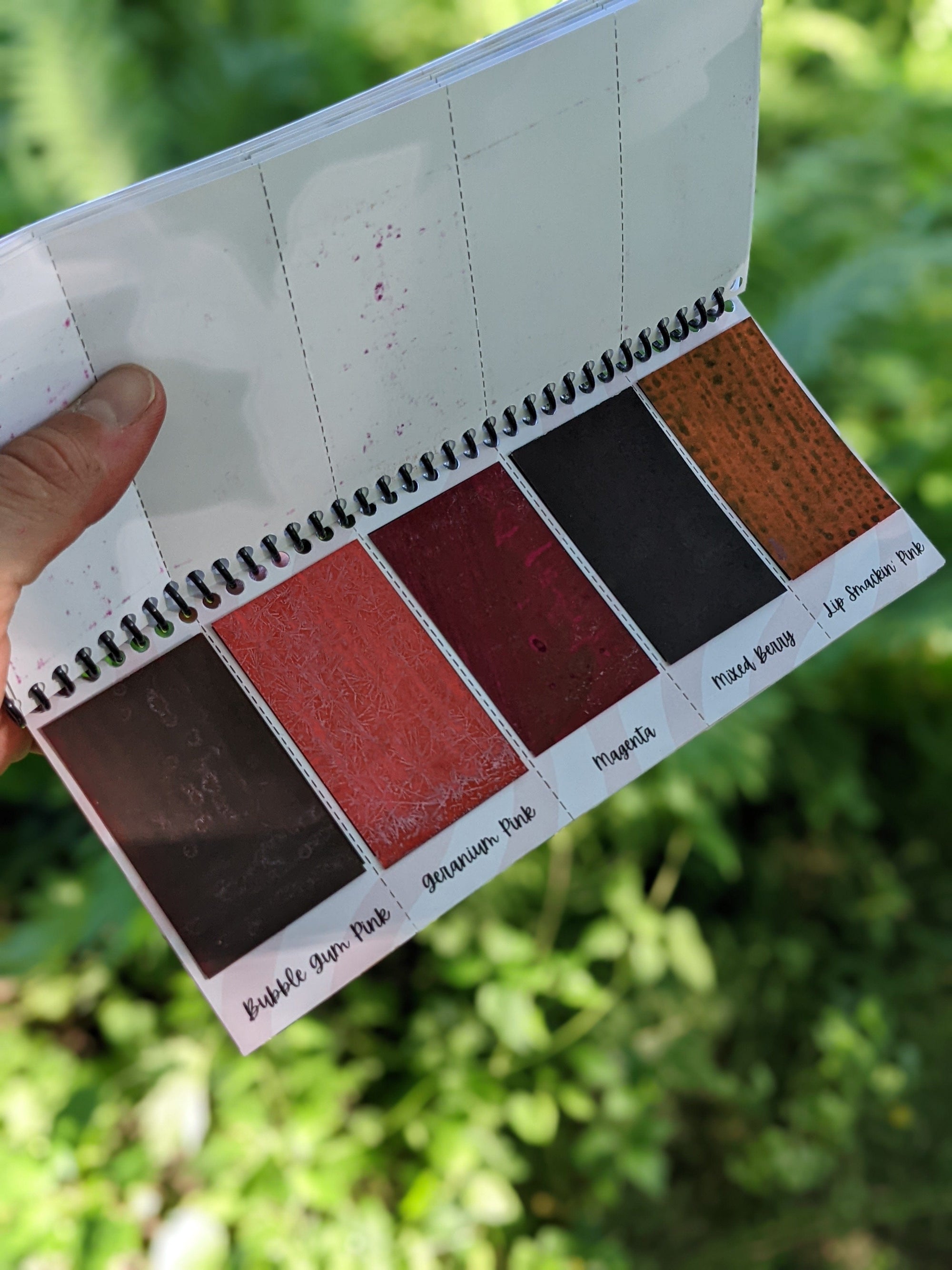 inside sheet of the peerless watercolors portable watercolor palette the Sidekick. This watercolor palette is super vibrant, portable, and easy to use.  this picture is showing of the pink paints included in the travel watercolor palette.
